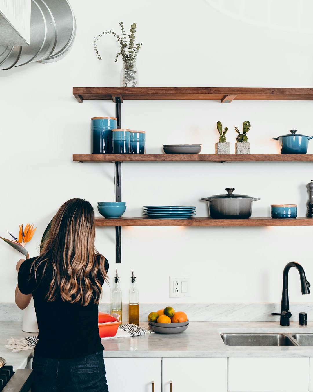 woman-standing-in-front-of-kitchen-sink-1wfxk3wjxzu